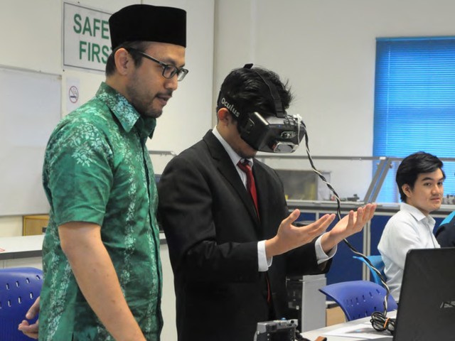 Demonstrating a VR headset to a student in the lab