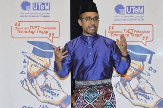 Dr Nurulfajar Abd Manap speaking at a UTeM TVET forum in traditional Malay attire