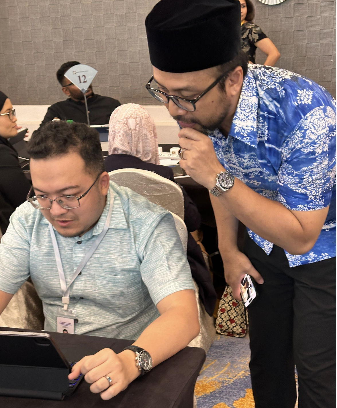 Mentoring a participant on an iPad during a judging session